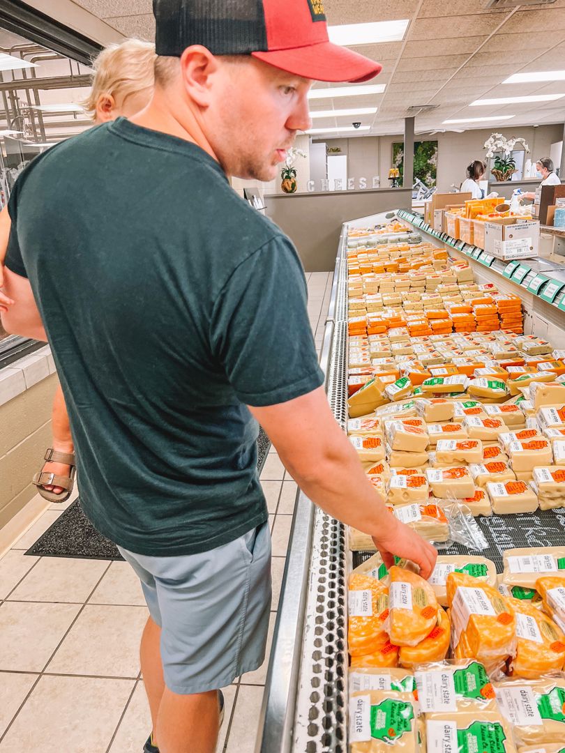 Father Holding Son While Shopping for Cheese - @thekuzickiadventures.jpg